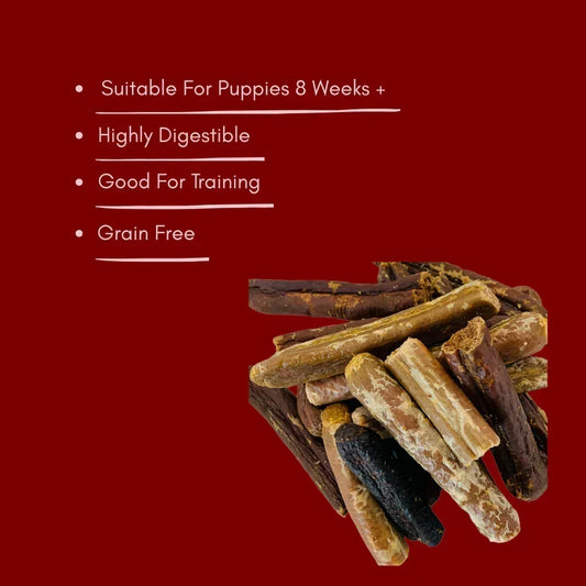 Assorted natural mixed broken dog sausages, grain free and suitable for puppies, on red background.