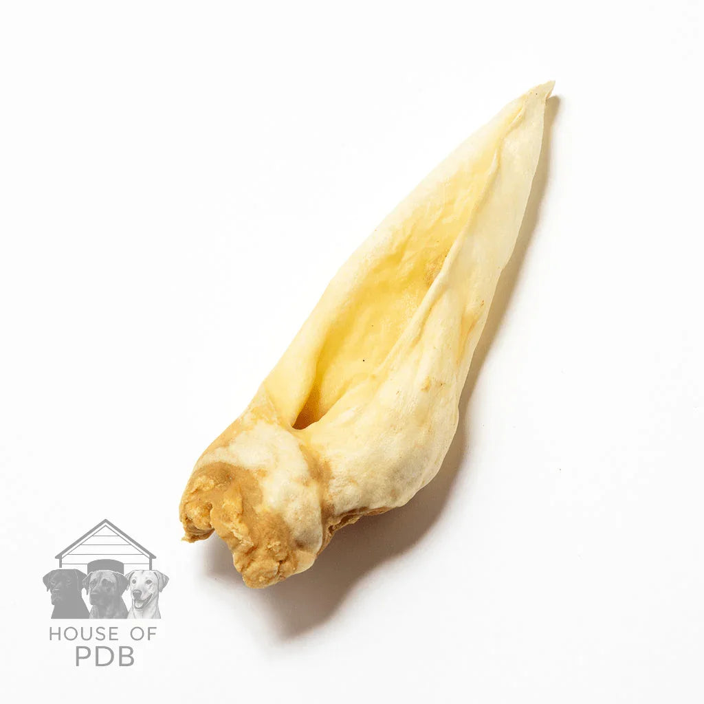 Single natural dried goat ear dog chew on white background with House of PDB logo