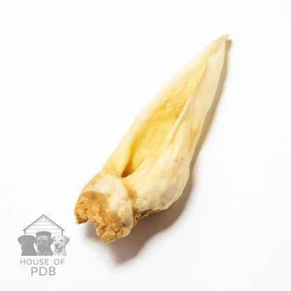 Single natural dried goat ear dog chew on white background with House of PDB logo